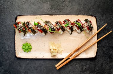 Yemek çubuklarıyla servis edilen suşi ruloları. 