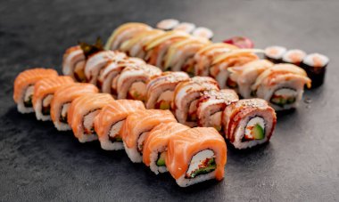 Sushi siyah taş arka planda yuvarlanıyor.
