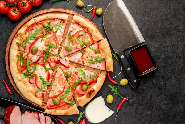 Siyah masa yüzeyinde malzemeleri olan pizza.