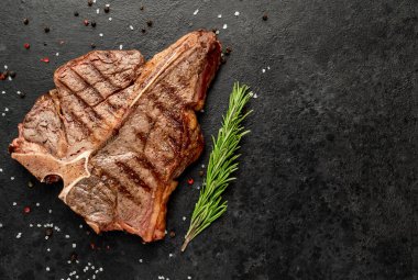 Baharatlı ızgara biftek ve siyah arka planda biberiye.