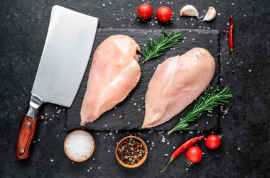 Baharatlı çiğ tavuk göğsü ve siyah taş kaplama otlar. Üst Manzara. Metnin için boş yer