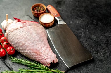 Biberiyeli çiğ hindi budu ve siyah arka planda baharatlar. en üstteki görünüm. 