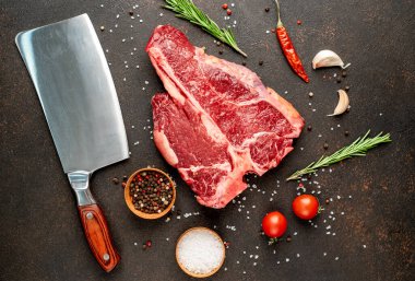 Biberiyeli çiğ biftek ve siyah masada domates.