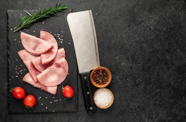 Baharatlı domuz jambonu ve siyah arka planda otlar.