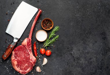 Siyah arka planda baharatlı ve sebzeli çiğ biftek.