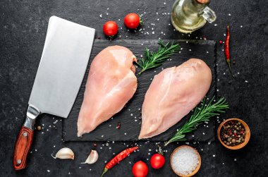 Baharatlı çiğ tavuk göğsü ve siyah taş kaplama otlar. Üst Manzara. Metnin için boş yer