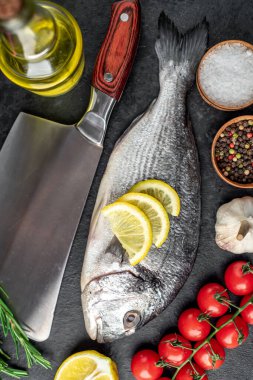 Limonlu çiğ dorado balığı ve ahşap arka planda baharatlar.