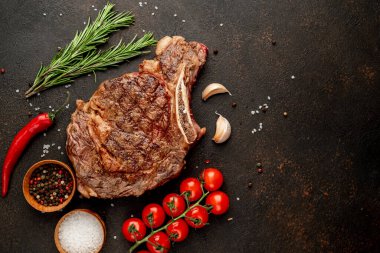 Baharatlı ızgara biftek ve siyah arka planda biberiye.