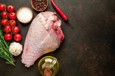 Baharatlı çiğ hindi budu ve siyah arka planda otlar. Üst Manzara. Metnin için boş yer.