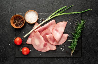 Baharatlı domuz jambonu ve siyah arka planda otlar.