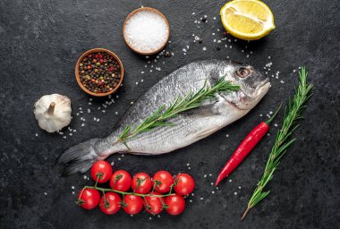 Biberiyeli çiğ balık ve siyah taşlı bitki. en üstteki görünüm.