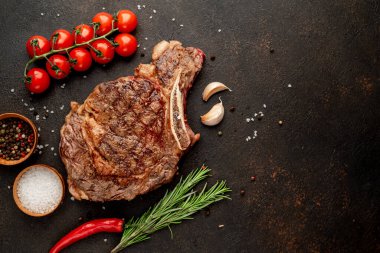 Baharatlı ızgara biftek ve siyah arka planda biberiye.