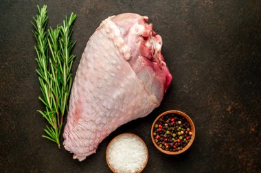 Biberiyeli çiğ hindi budu ve siyah arka planda baharatlar. en üstteki görünüm. 