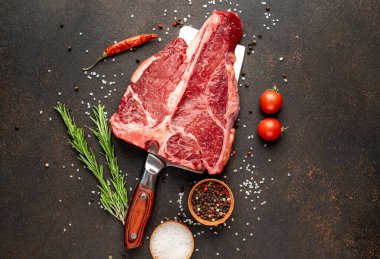 Biberiyeli çiğ biftek ve siyah masada domates.