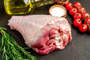 Baharatlı çiğ hindi budu ve siyah arka planda otlar. Üst Manzara. Metnin için boş yer.