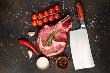 Biberiyeli çiğ biftek ve siyah arka planda baharatlar.