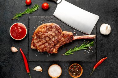 Siyah arka planda baharatlı ızgara biftek ve otlar. 