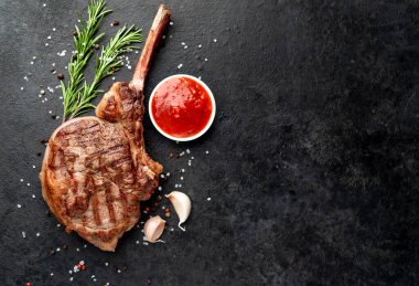 Baharatlı ızgara biftek ve siyah taş kaplama otlar. en üstteki görünüm.