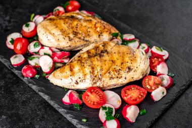 Izgara tavuk göğsü. Sebze ve baharatlı. Siyah arka planda..