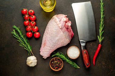 Biberiyeli çiğ hindi budu ve siyah arka planda baharatlar. en üstteki görünüm. 