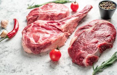 Biberiyeli çiğ et ve siyah arka planda bitkiler. 