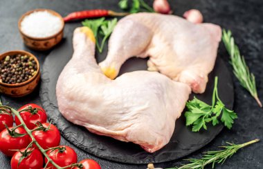 Tahtadaki baharat ve otlarla çiğ tavuk bacağı..