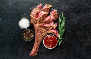 Baharatlı ızgara et ve siyah arka planda otlar. 