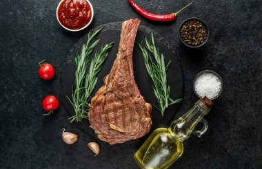 Baharatlı ızgara et ve siyah arka planda otlar. 