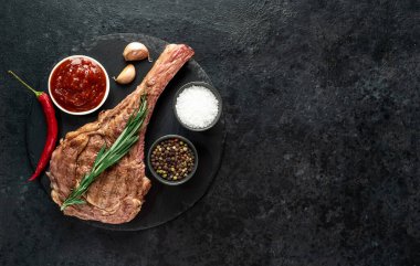 Baharatlı ızgara et ve siyah arka planda otlar. 