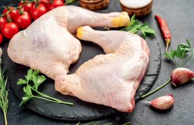 Tahtadaki baharat ve otlarla çiğ tavuk bacağı..