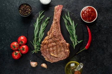 Baharatlı ızgara et ve siyah arka planda otlar. 