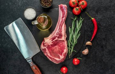 Biberiyeli çiğ et ve siyah arka planda bitkiler. 