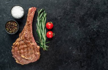 Baharatlı ızgara et ve siyah arka planda otlar. 