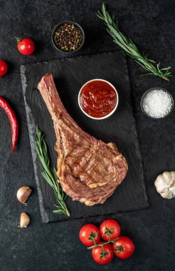 Baharatlı ızgara et ve siyah arka planda otlar. 