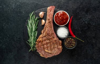 Baharatlı ızgara et ve siyah arka planda otlar. 