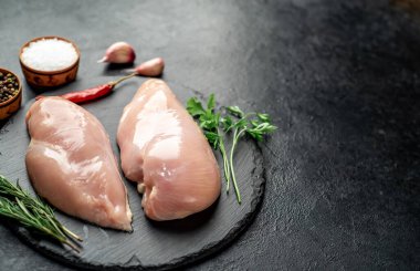 Tahtada baharat ve bitkilerle çiğ tavuk göğsü.. 