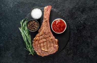 Baharatlı ızgara et ve siyah arka planda otlar. 