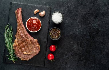 Baharatlı ızgara et ve siyah arka planda otlar. 