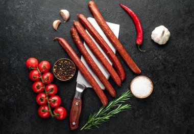 Siyah arka planda çiğ sosis ve sebzeler. Üst Manzara. Metnin için boş yer.