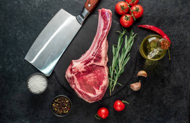 Biberiyeli çiğ et ve siyah arka planda bitkiler. 