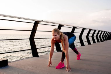 Genç bir kadın şafak vakti okyanus manzaralı sette yoga yapıyor..