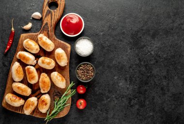 Siyah arka planda baharatlı ve otlu tavuk fileto sosisi. en üstteki görünüm.