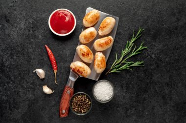 Siyah arka planda baharatlı ve otlu tavuk fileto sosisi. en üstteki görünüm.