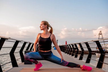 Genç bir kadın şafak vakti okyanus manzaralı sette yoga yapıyor..