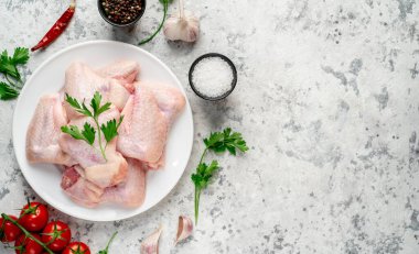 Hafif arka planda baharat ve bitkilerle çiğ tavuk kanadı. Üst Manzara. Metnin için boş yer