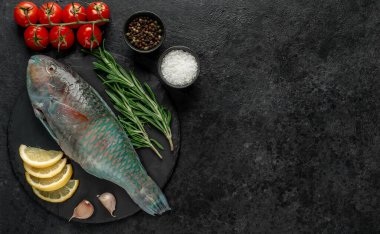 Siyah zemin üzerinde limonlu çiğ balık ve biberiye.