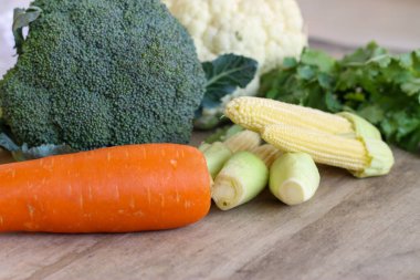 Tahta bir masada taze ve lezzetli sebzeler koleksiyonu.