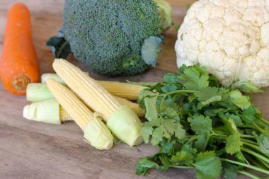 Tahta bir masada taze ve lezzetli sebzeler koleksiyonu.