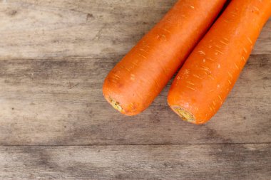 Eski bir ahşap arka planda iki havuç çok güzel görünüyor.