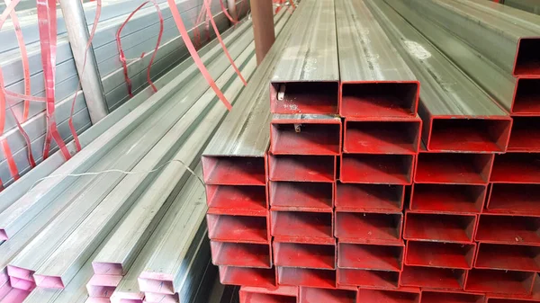 square metal pipe Carbon Steel Pipe Section Stainless steel bars are stacked on top of each other in a metal product warehouse.